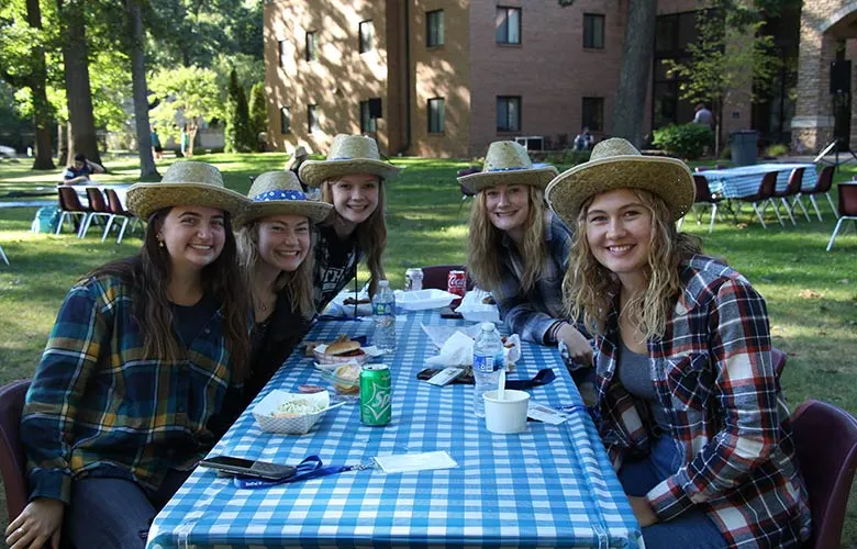 alumni-ho-down 5 female students at table with straw hats