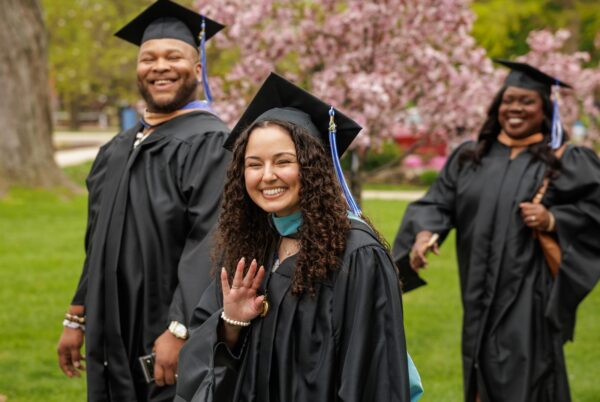 graduates walking through Bethel's campus