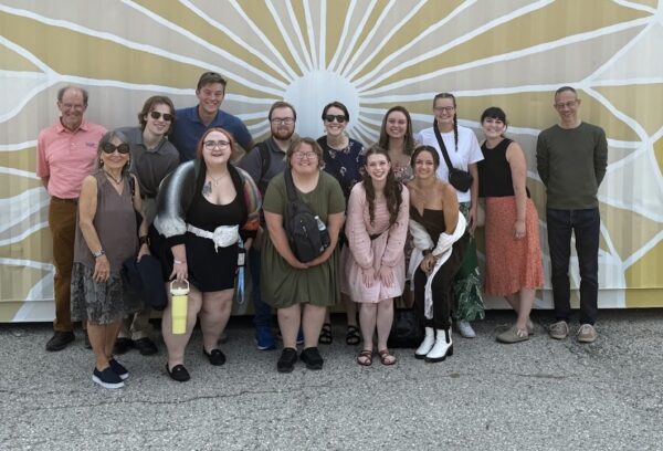 Bethel University students pose outside Stratford's Costume and Prop Warehouse before touring one of the world's largest theatrical costume and prop collections.