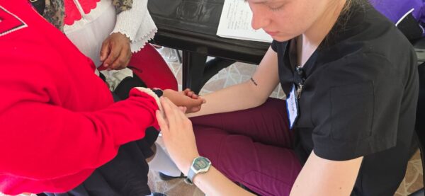 Peyton Dickinson provides hands-on care to a patient during a Nursing Task Force medical clinic in Ecuador.