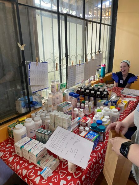 Peyton Dickinson works at a table filled with medications and medical supplies during a Nursing Task Force clinic in Ecuador.