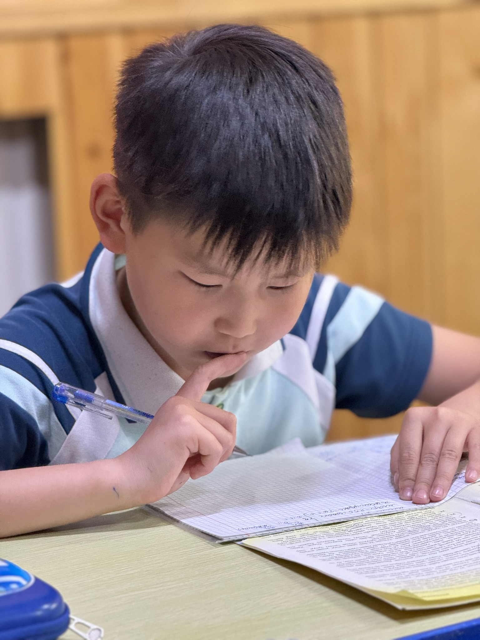 A young Mongolian student concentrates while completing schoolwork during an educational program supported by ministry partners.