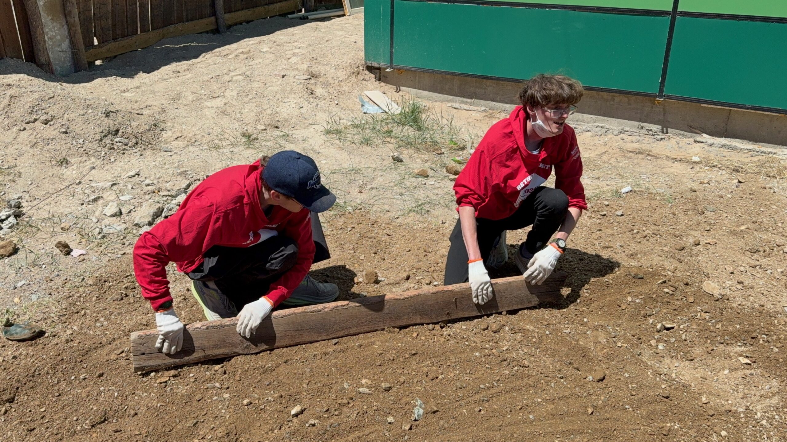 Two Bethel University Task Force students level soil together during a service project in Mongolia.