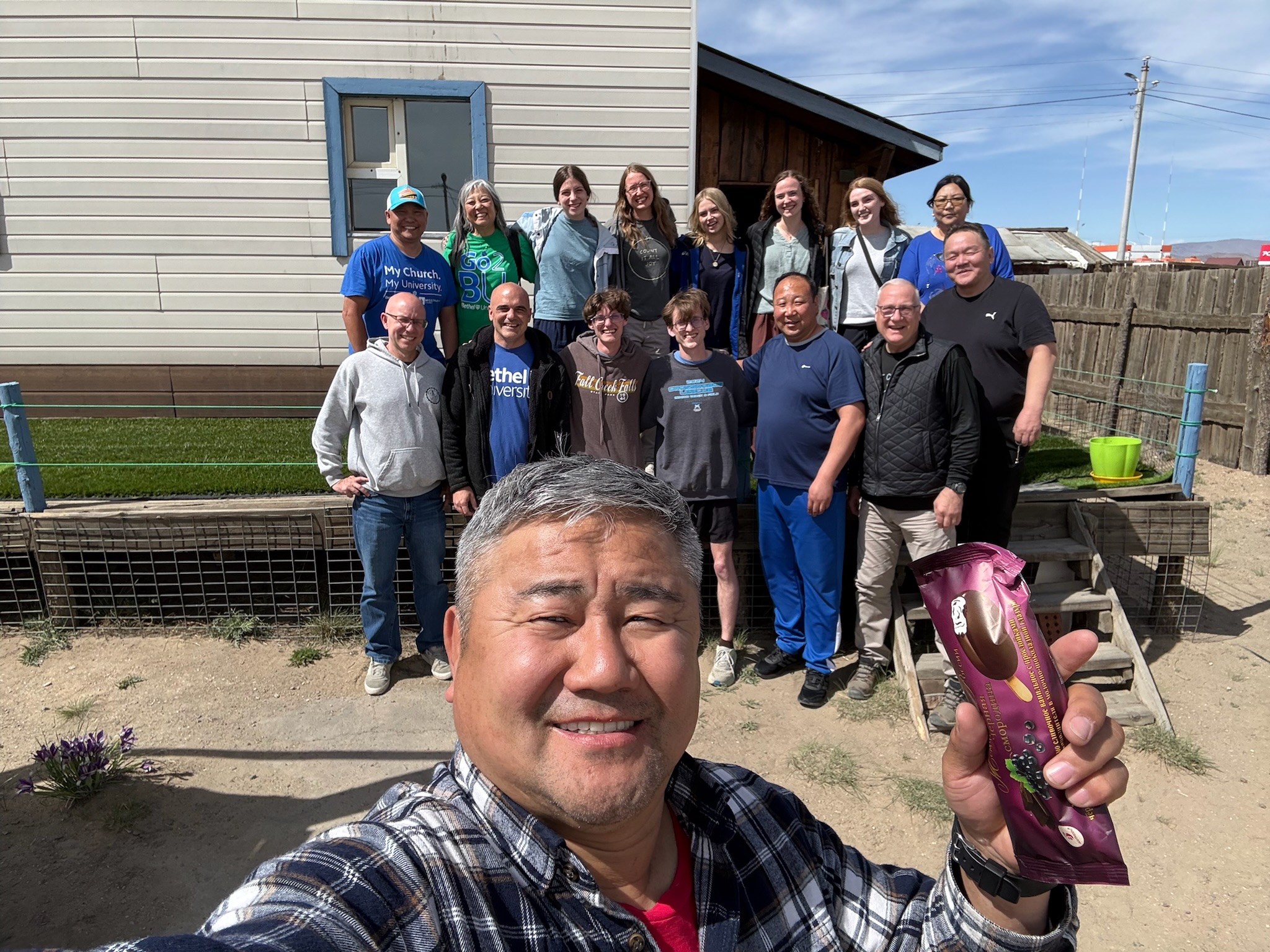 Bethel University Task Force members and Mongolian ministry partners pose together outside a church building in Mongolia during the team's visit.