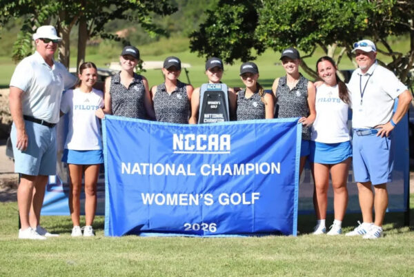 Bethel University women’s golf team and coaches pose with the 2026 NCCAA National Champion banner and trophy after winning the national championship.